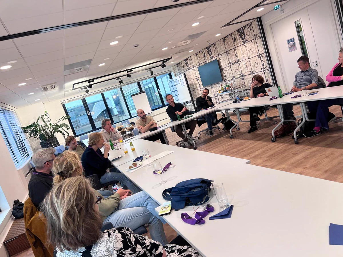 UX managers in discussie aan grote tafel
