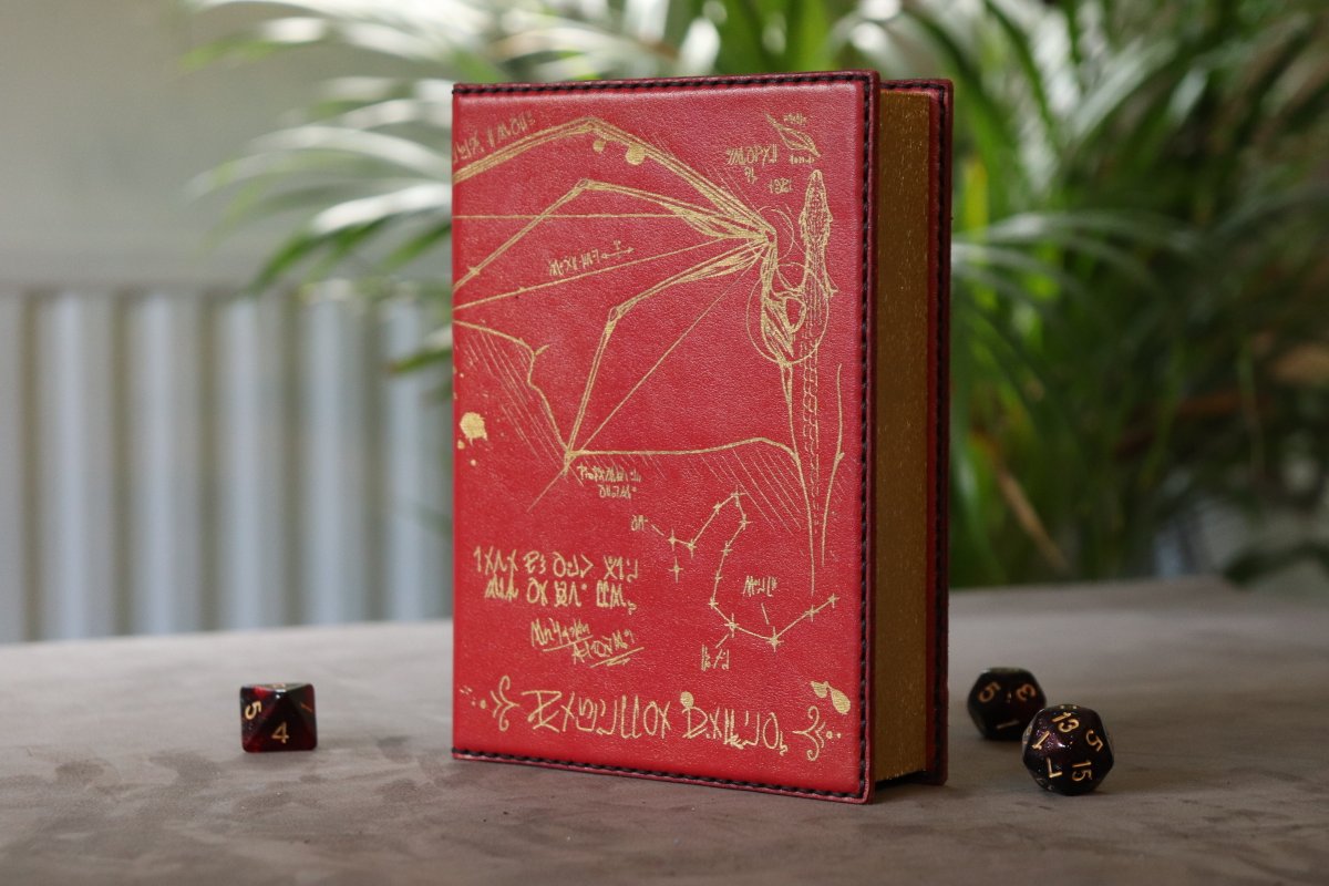 SpeechlessBard's tweet image. A red leather Dragon Caster Compendium (double sized) with gold inlay and gold magnets for the Spell Slot Tracker 📕
This unique spell book (with space for two stacks of spell cards or extra dice) will be part of today's shop update at 8pm CEST ✨
#ttrpg #dnd #castercompendium