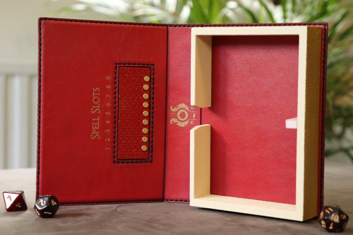 SpeechlessBard's tweet image. A red leather Dragon Caster Compendium (double sized) with gold inlay and gold magnets for the Spell Slot Tracker 📕
This unique spell book (with space for two stacks of spell cards or extra dice) will be part of today's shop update at 8pm CEST ✨
#ttrpg #dnd #castercompendium