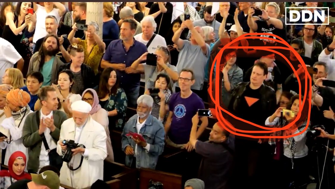 HeidiBachram's tweet image. At the Roger Waters pro-Pal event yesterday at @StPancrasChurch someone in the audience was wearing a shirt with the red triangle of Hamas on it. Is the church ok with terror support on their premises? @metpoliceuk