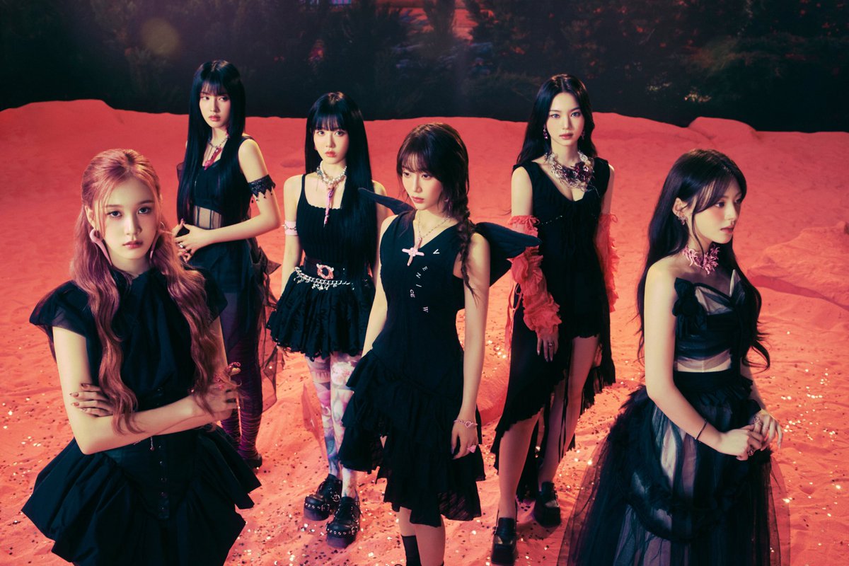 In this metamorphic concept photo, STAYC embodies a cheeky yet fiercely elegant presence amid electric skies and fiery sands. Their aura blends strength and beauty seamlessly, crafting a narrative of bold transformation that merges graceful allure with rebellious charm.