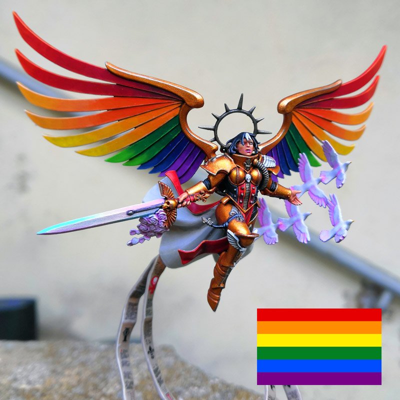CerberusXt's tweet photo. What better time than pride month to finally paint the centerpiece of my pride theme Sisters of Battle series, Celestine the living saint!

Quite a tricky mini to paint with how fiddly she is, but her wings are the perfect canvas for the rainbow flag.

I hope you like her. https://t.co/zBxhagdqt3