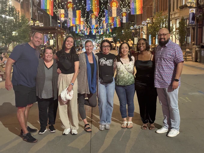Microsoft Flip/Learning Team in Denver, CO on the street with state flags and Pride flags above