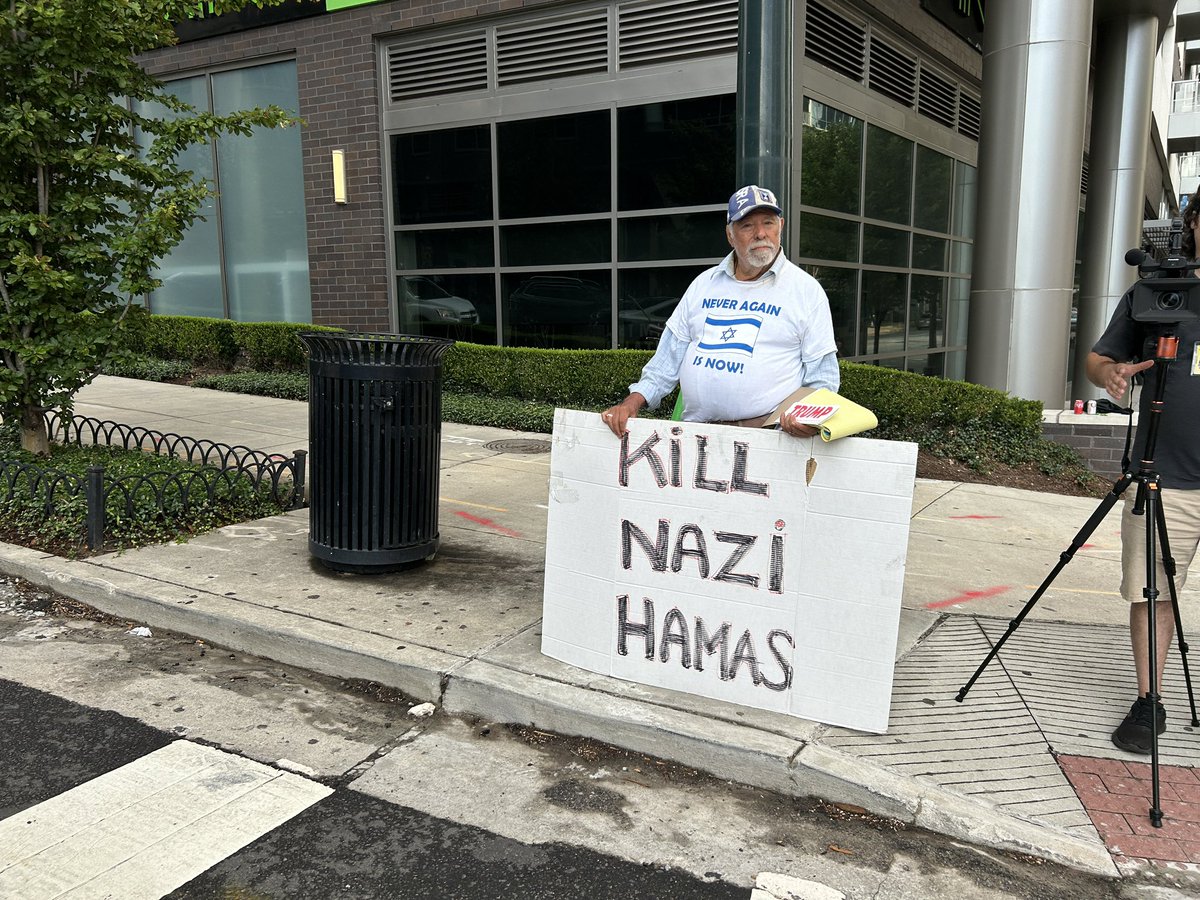 RobDiRienzo's tweet photo. Happening now: A group of pro-Palestinian protesters have gathered two blocks from the CNN debate on 10th Street. Meanwhile, a lone pro-Trump/Israel supporter stands across the street. @FOX5Atlanta https://t.co/eYYQJ9sJ9A