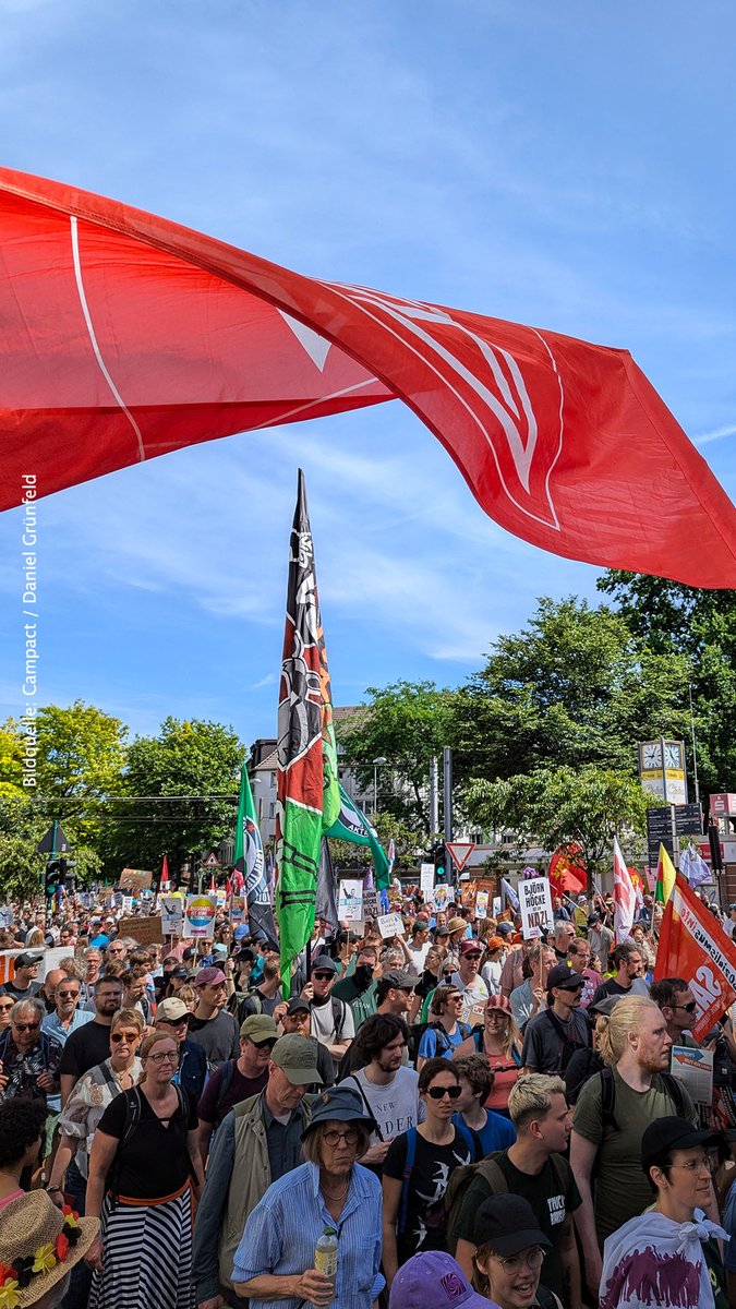 eine sehr große Gruppe bunter Menschen, die friedlich demonstrieren, und diverse Flaggen und Banner und Plakate tragen
