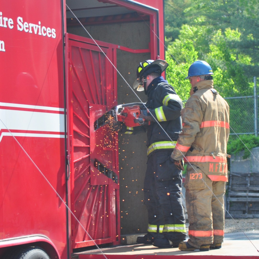 MassDFS's tweet photo. #Firefighters sometimes need to make rapid entry into a locked building. This Mass Fire Academy recruit is training w/ a #K12 power saw under the guidance of an instructor at our #ForcibleEntry Trailer. This trailer can be delivered to local fire departments to hone those skills. https://t.co/u48yzx1DeS