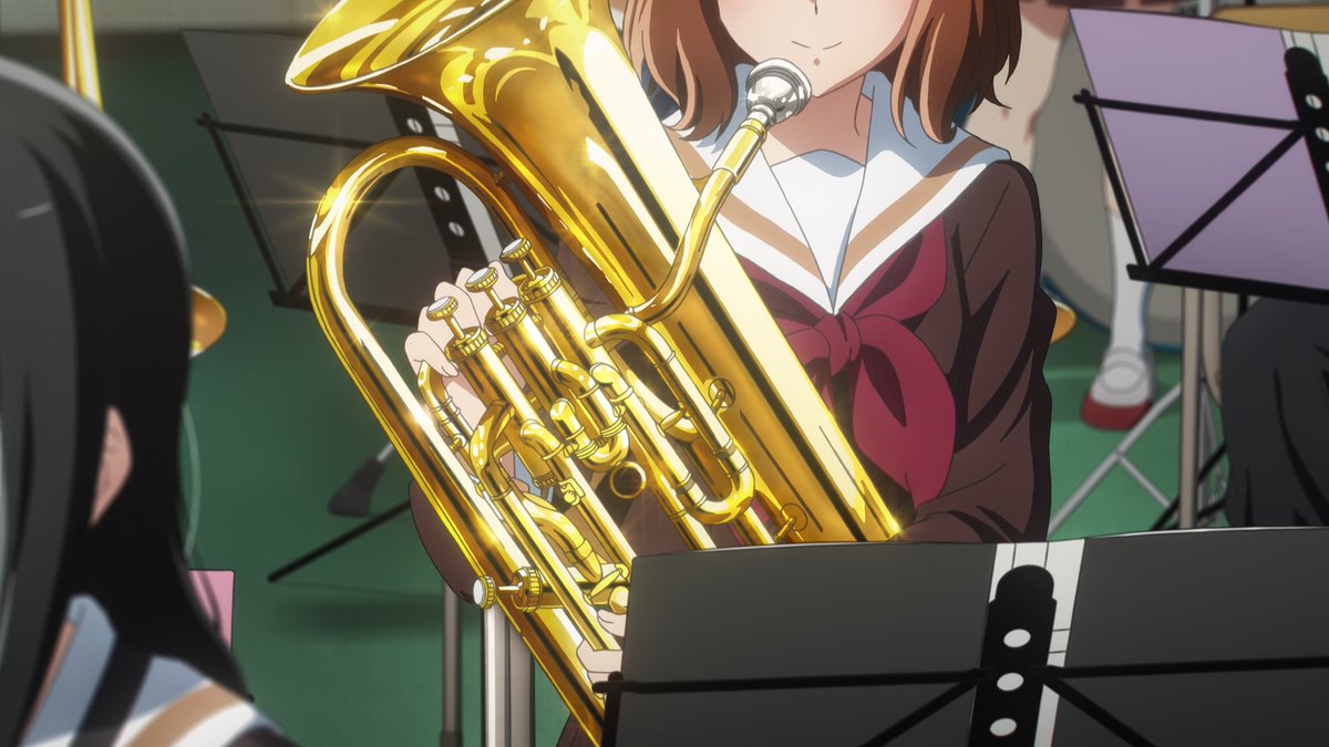 Yuyucow's tweet image. The girl that catches Kumiko's eye the most is the golden euph player the staff used to pull off that trick in the prologue. We know she's a first-year by the red. She plays a golden instrument, and by her side there's silver euph third year just like Asuka. The cycle continues