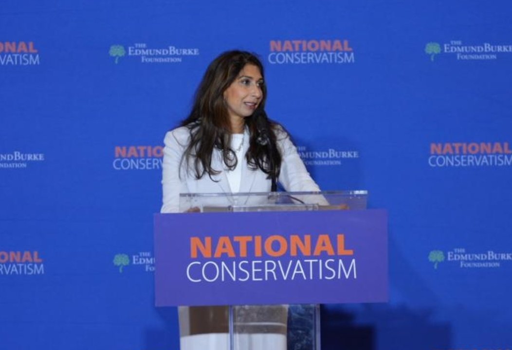 Parody_PM's tweet photo. After being re-elected, Suella Braverman gets straight back to serving her constituents by flying to the US to spout bollocks at the far right Nat Con event with the likes of Steve Bannon. #NatC https://t.co/nzPqSnzPJJ
