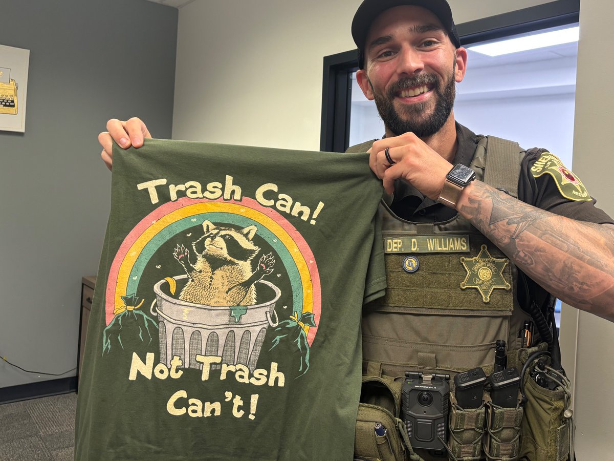 "We're trying to be friends here." 🦝 <a href="/NKCSchools/">NKC Schools</a> &amp; <a href="/SheriffClayCo/">Clay County, Missouri Sheriff</a> SRD Dakota Williams rescues two restless raccoons trapped after dumpster diving! Now he has a t-shirt and admiration for his commitment to saving critters! 
See the video here- tinyurl.com/46dvxtm4