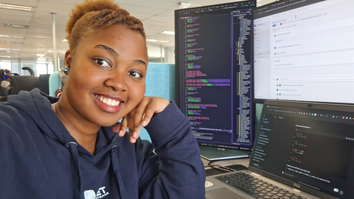 TreciaKS at her office desk, smiling towards at camera.