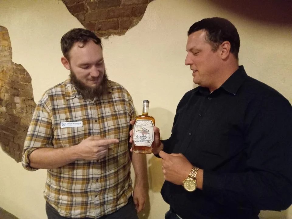 West Overton Co-Director Aaron Hollis Jr. (left) discusses whiskey bottled at West Overton with speaker Brady Crytzer, who spoke at West Overton this week about the Whiskey Rebellion. dailycourier.com/news/special-v…