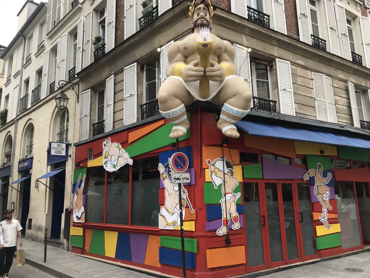 Pour les JO dans le Marais, la flamme olympique se révèle d'une surprenante créativité. Bravo au Café Cox pour ses déco saisonnières toujours amusantes et originales. Vu rue des Archives. Pour d'autres bonnes adresses du gay marais, suivez le guide : parismarais.com/fr/styles-de-v… 😅
