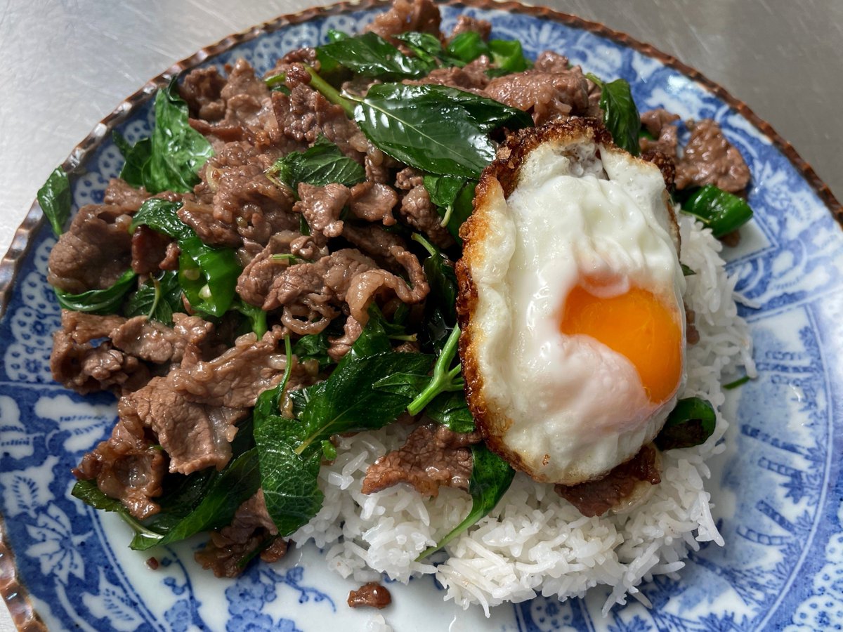 h_gashiyama's tweet photo. 牛肉のガパオライス(パット ガパオ ヌア)

タイで食べて感動して、僕が夏の間に何度も作る簡単激うまメシ

作り方は、マジ簡単
牛肉をナンプラー&オイスターソースでサッと炒めて、最後にハーブをたっぷり入れて混ぜる
それだけなのに、驚くほどうまい

ポイントは3つ
①安い外国産牛肉を使うこと→脂の少なさ＆ワイルドな香りが合う！
②青唐辛子orししとうを入れる→辛味というより唐辛子系の香りが重要
③ハーブをたっぷり入れる！→1番大事。紫蘇科が良くて、バジル・ミントがオススメだけど、日本の紫蘇も最高！ミックスしても良い！

<材料>
外国産牛こま肉
ニンニク
ししとうor青唐辛子
紫蘇科のハーブ
ナンプラー
オイスターソース
サラダ油

<作り方>
①牛肉を1cm幅位にカット(適当でok)
②ニンニクは潰してから適当に刻み、ししとうor青唐辛子は1cm幅にカット
③ハーブは手でちぎって茎と葉を分離
④フライパンに多めに油をしいて、牛肉を炒める
⑤牛肉に8割火が通ったらニンニク・ししとう(青唐辛子)を入れる
⑥ナンプラー＆オイスターソースで味付け
⑦完全に火が通って、味が整ったら、火を止めてからハーブ類をたっぷり入れる
⑧サックリと一回混ぜて完成
※ハーブに火を入れすぎると香りが飛ぶので注意！！

あとは、米にぶっかける
ジャスミンライスだと最高だけど、日本米でも十分うまい！
目玉焼きを乗せてあげると更に最高

いつ食ってもうまいけど、夏に汗をかきながらがっつくのが1番うまい