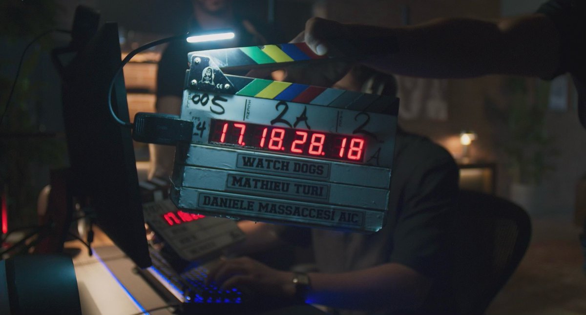 A photo of a clapperboard, taken on set of the Watch Dogs Movie. The backdrop appears to be someone on a computer. 