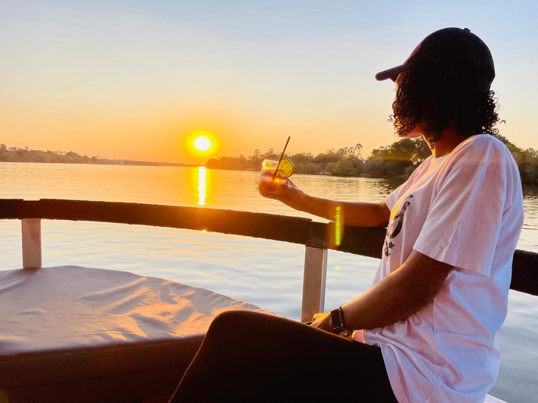 Watching the Aftican sunset, relaxing and sipping on your favorite sundowner while cruising along the Zambezi river is the best way to round off your day when on a safari in Zimbabwe. #TravelInspiration #visitzimbabwe #Safari #elecheetah