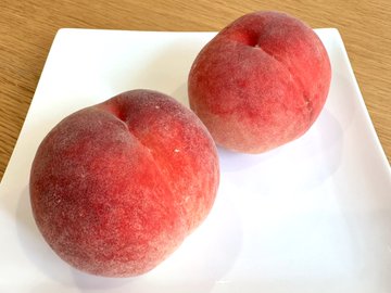 お皿の上に桃が2個載っています。