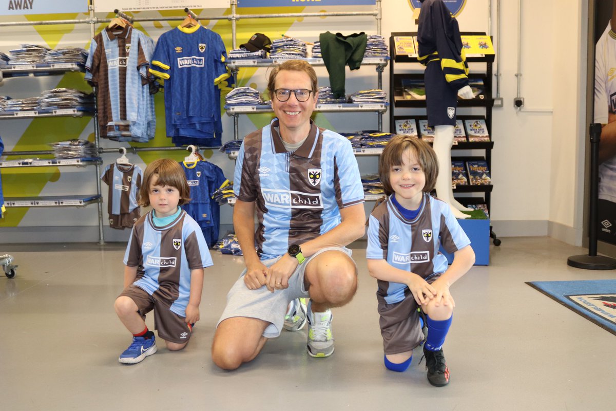 AFCWimbledon's tweet photo. Here’s Craig with Zach and Nate rocking our new @umbro away shirt 🤎🩵

Available in-store and online here 👉 https://t.co/YdBz99VyXT

#AFCW | @afcw_women | @umbro | @WarChildUK | @SportsInt 🟡🔵 https://t.co/A2YECRcaBo