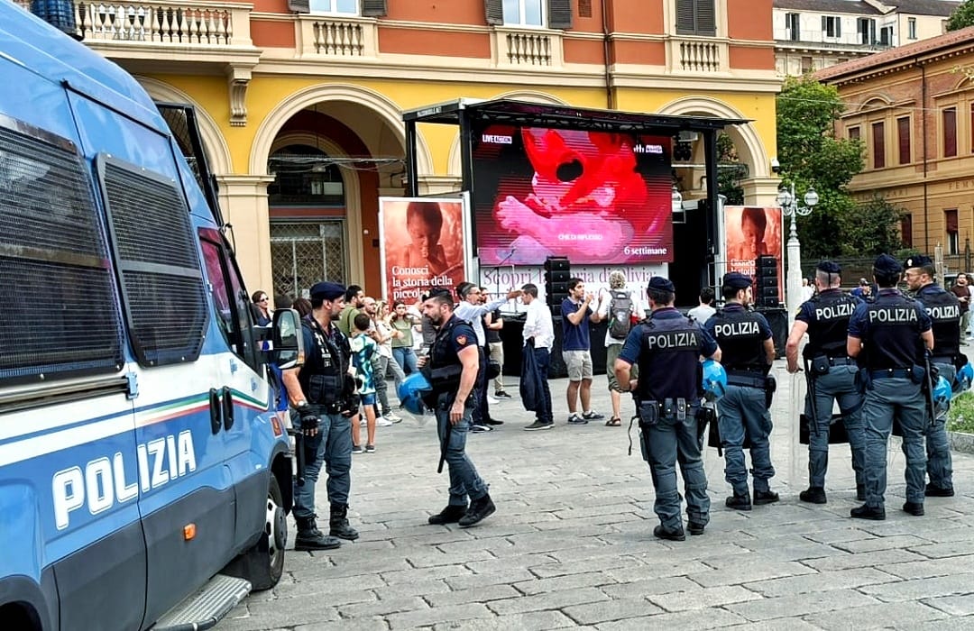ProVitaFamiglia's tweet photo. 🔴 BABY OLIVIA: CENTRI SOCIALI ATTACCANO LA PROIEZIONE DEL VIDEO A BOLOGNA. CON LORO CONSIGLIERI PD

Oggi abbiamo proiettato in piazza a Bologna, muniti di tutte le dovute autorizzazioni, il video di #BabyOlivia, che racconta con assoluto rigore scientifico l'origine e lo sviluppo della vita nel grembo materno dal concepimento alla nascita.

Poco dopo l'inizio della proiezione, si è radunata nella stessa piazza una contro-manifestazione non autorizzata - composta da alcune decine di persone appartenenti a centri sociali e collettivi femministi. Presenti anche alcuni Consiglieri comunali del Partito Democratico.

Gli attivisti di estrema sinistra hanno provato a disturbare e impedire lo svolgimento dell'evento prima urlando insulti e bestemmie e poi avvicinandosi fisicamente al palco, dove era istallato il maxischermo, per lanciare contro gli organizzatori volantini e preservativi e tentando addirittura di scollegare i cavi di alimentazione dell'impianto audio-video per interrompere le trasmissioni e censurare "Baby Olivia",  colpevole di raccontare la storia della loro stessa origine.

Il clima di tensione e violenza si è talmente surriscaldato che le forze dell'ordine hanno dovuto schierarsi a difesa dello schermo e dei presenti, tra cui il Capogruppo della Lega in Consiglio Comunale, Matteo Di Benedetto, e il neoeletto Deputato europeo di Fratelli d'Italia Stefano Cavedagna, che ringraziamo per la solidarietà.

È veramente allucinante: a causa dell'odio della Sinistra contro la realtà dei fatti, per poter divulgare pubblicamente come inizia e si sviluppa la vita umana nell'utero secondo le evidenze scientifiche è necessaria la scorta e la protezione da parte forze dell'ordine.

Evidentemente, la Costituzione Italiana che sancisce il diritto di opinione e di libera manifestazione del pensiero di tutti i cittadini non trova applicazione nella Bologna "progressista" e "democratica".

Non cederemo ad alcuna forma di minaccia, violenza o intimidazione: venerdì 26 luglio saremo in piazza ad Ancona per continuare la proiezione pubblica del video di Baby Olivia in tutta Italia.

🔴 Reagisci con noi a questo attacco: condividi e diffondi il Link del video di Baby Olivia👇🏼
https://t.co/pQ6vnpSGPf