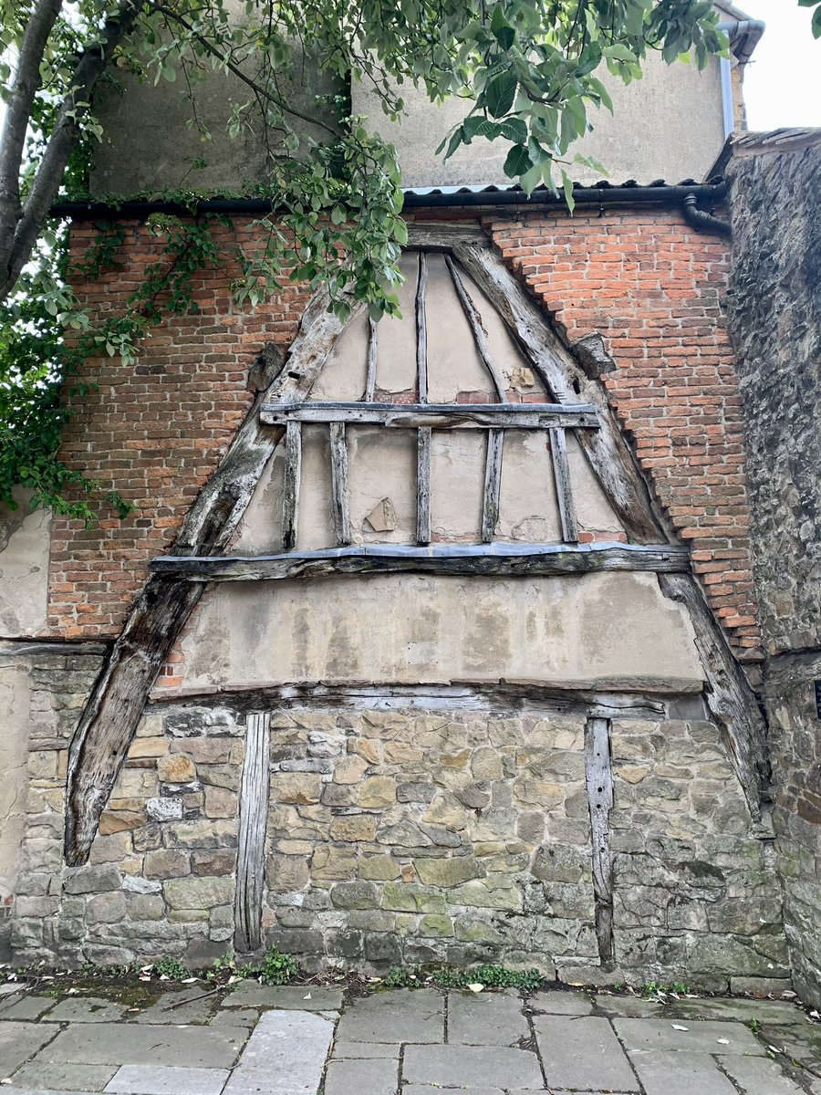 The historic town of Wirksworth in Derbyshire boasts unique ancient structures, including a medieval cottage wall from the 1400s. This wall, a remnant of cruck construction, is common in Derbyshire &amp; has a distinctive "A" shape roof.