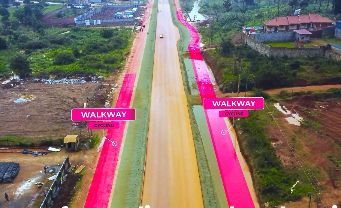kiyagaedwin's tweet photo. Why is the paved section of the Kira-Kasangati-Matugga road smaller compared to the total width of the road under construction? To find out read below. (Detailed Video in Frame 4)

The Kira-Kasangati-Matugga project aims to upgrade the entire road to paved standards, with a design that includes:

     (I) 3.5-meter lanes: Standard lane width for vehicular traffic.
     (II)1.5-meter shoulders: Provide safety margins and space for breakdowns.
      (III)4.0-meter green belt:Promotes environmental benefits and future lane expansion.
       (IV)2.0-meter cycle lane:Encourages eco-friendly transportation.
        (V)2.0-meter pedestrian walkway:Improves safety for non-motorized users.

The cycle lane specifically aligns with promoting zero-emission transport and environmental benefits. 

While the paved section is still in progress, the road's width accommodates these planned features for a safer and more sustainable transportation infrastructure in the future. #UNRAworks