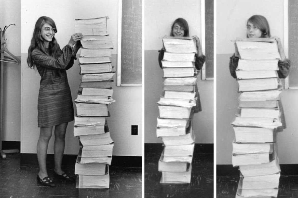 Margaret Hamilton stands next to code written by hand for the moon landing in 1969.