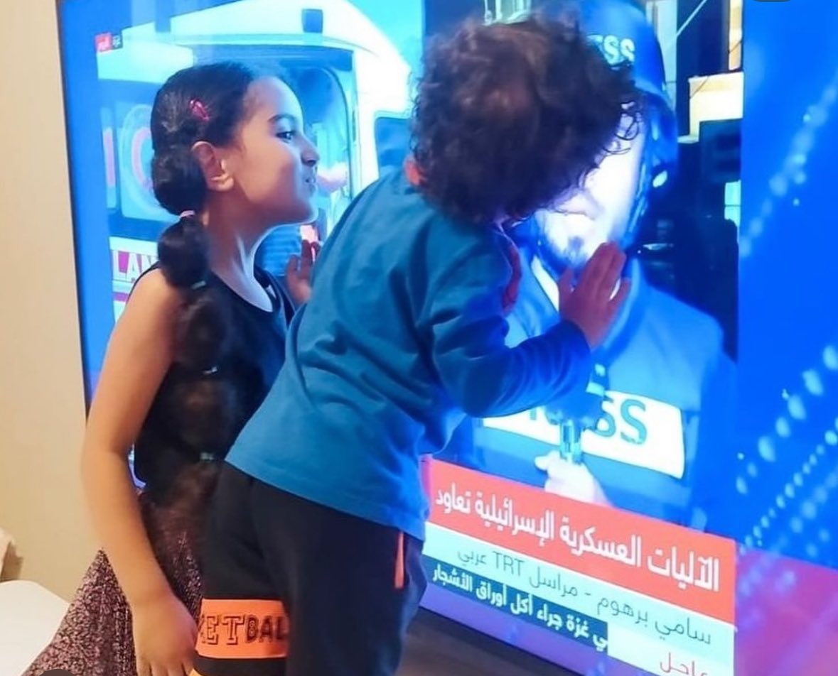 missfalsteenia's tweet photo. The children of a Palestinian journalist, Sami Barhoom, kiss their father on a tv screen because he’s still reporting in Gaza while they’re in Turkiye. 

May they reunite soon ❤️‍🩹 https://t.co/ydzWwKM0AC