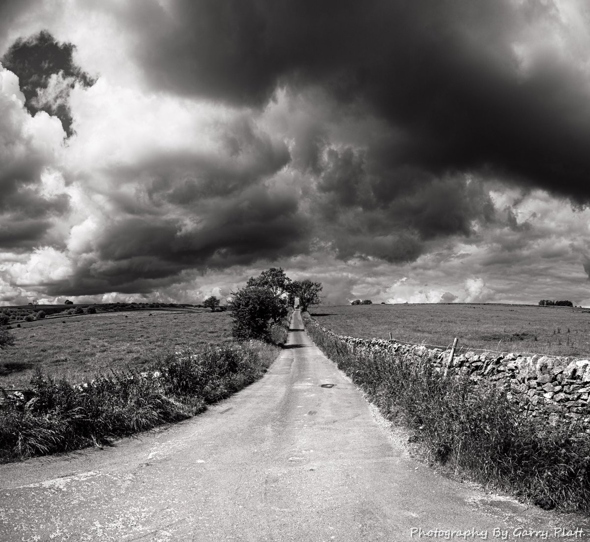 Storm Clouds Gather - High above Castleton in Derbyshire a single lane trackway cuts through the fields heading towards Tideswell. On the day I passed through storm clouds were gathering in the distance and dark skies rolled across the landscape.