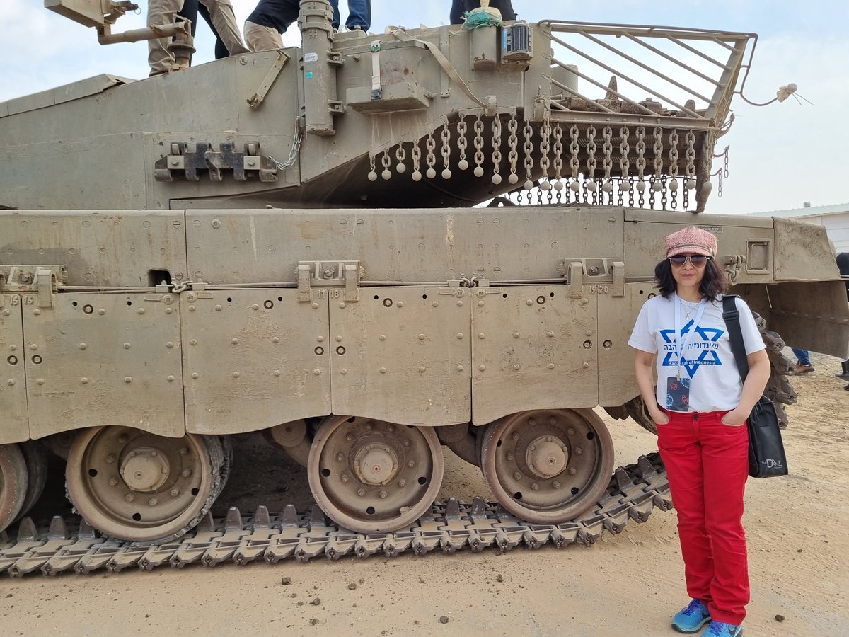 Fakta_Israel's tweet photo. Desember 2022, cuma 2 km dari perbatasan Gaza, saya mejeng dekat tank IDF di pangkalan militer IDF.  Waktu itu, warga Gaza masih banyak yang bisa bekerja di Israel. Bahkan pelayan saat kami makan siang di kibbutz dekat markas IDF ini muslimah, karena berjilbab. #StandWithIsrael https://t.co/SZ0CdlOPD7