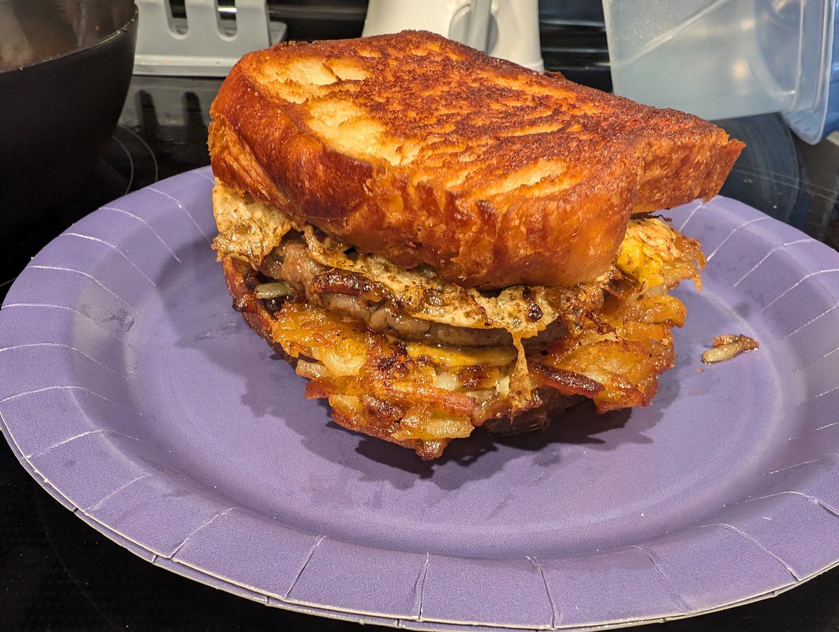 ChristianInIndy's tweet photo. Hash browns, @bobevansgrocery zesty hot sausage, cheese, and egg, seasoned with @MeatChurch Honey Bacon BBQ rub on croissant loaf bread. I think I've nearly perfected my breakfast sandwich. https://t.co/jmUqgegKgM
