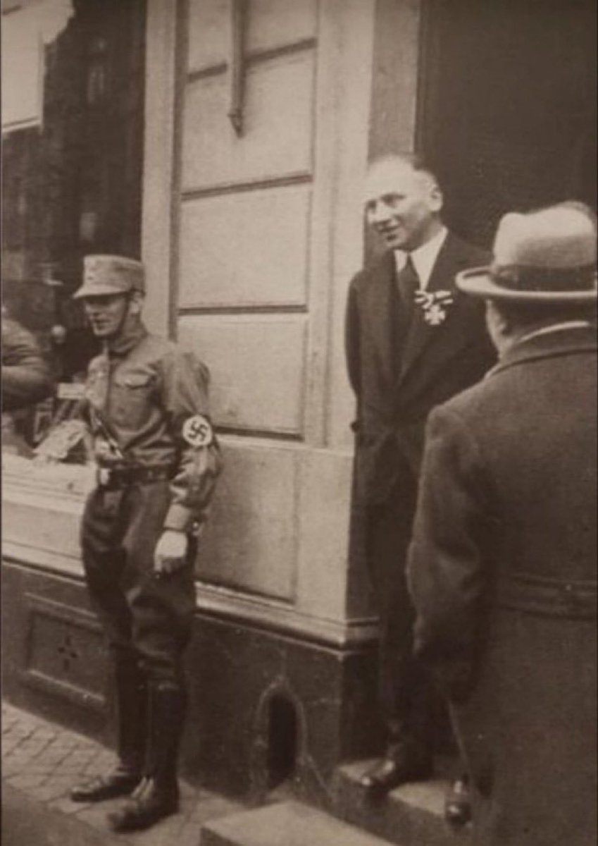floridanow1's tweet photo. A German-Jewish WWI veteran wears his Iron Cross (2nd highest combat decoration) while a Nazi soldier stands in front of his shop in an effort to intimidate him, 1933.   

The man’s name was Richard Stern. He emigrated to the US in 1939, just a few months before WW2 began. He then enlisted in the US Army in 1942 at age 43 and fought the Nazis directly in battles throughout Italy.   

He was awarded the Silver Star (3rd highest combat decoration) in 1944. That Iron Cross he was wearing in this photo? He donated it to the US scrap metal program to make bullets for the war effort. A true American (and German) hero, Richard Stern passed away in 1967.
📽️Upliftingvision