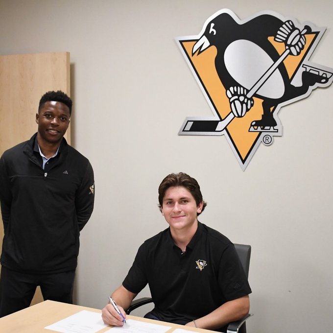 Photo of Tanner Howe signing contract with Vukie Mpofu.