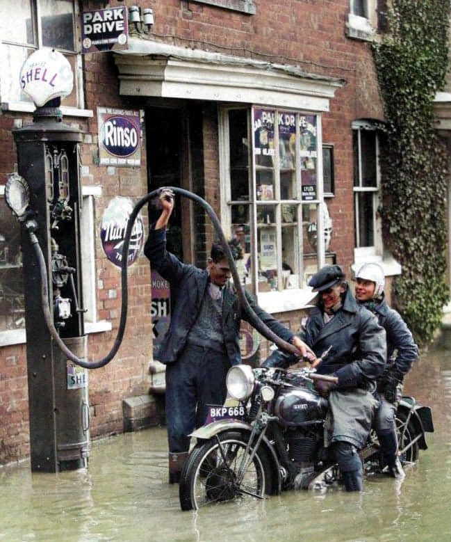 englandincolour's tweet photo. Filling up at a Shell garage during a flood in 1935. #petrolpump #petrolstation #shellgarage #1930s #flood #colourised https://t.co/EVBwbBtrXO