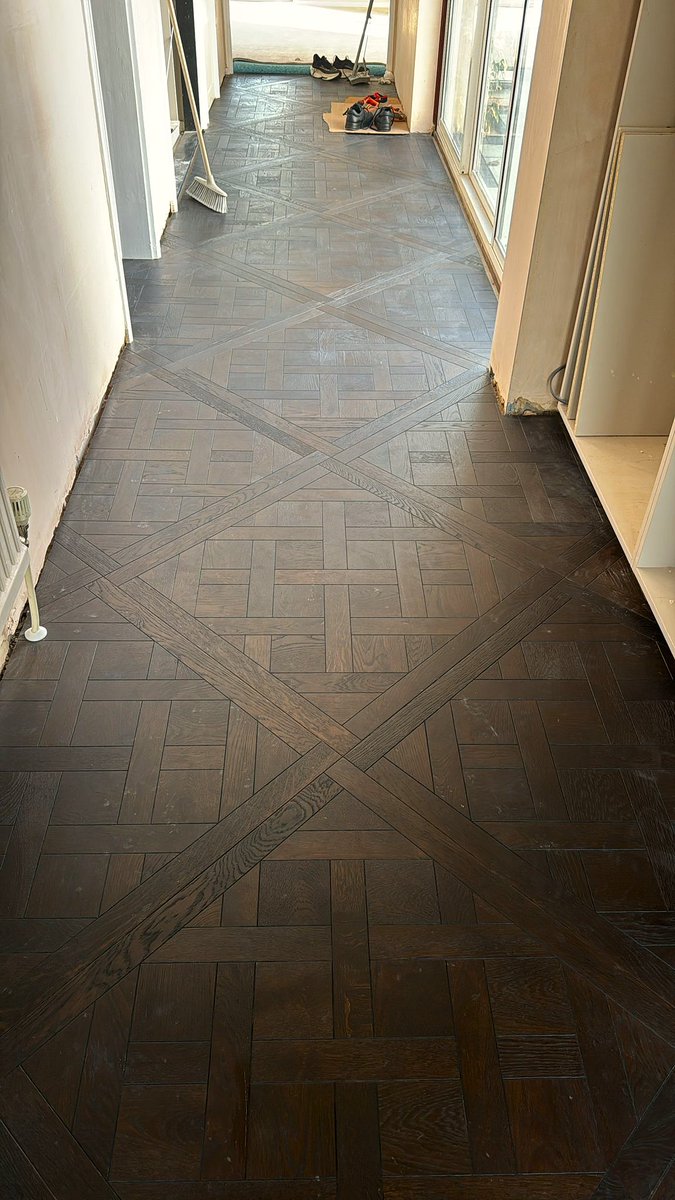 This hallway just got a luxurious upgrade with our bespoke Smoked Wenge Oak Engineered Versailles Wood Panel Flooring. #HomeDesign #LuxuryFlooring #VersaillesPanels #CustomCrafted #InteriorInspo #brilliantwoodflooring