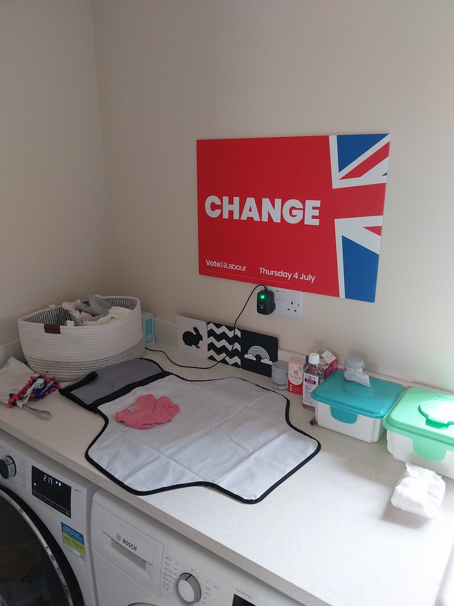 Labour party "change" placard above a baby changing area.
