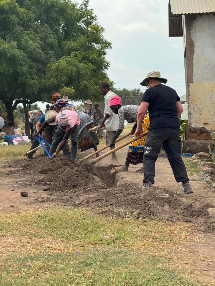 A rewarding but tough day. 53 banana trees planted, water trench pipe laid and recovered with soil and a toilet block painted!