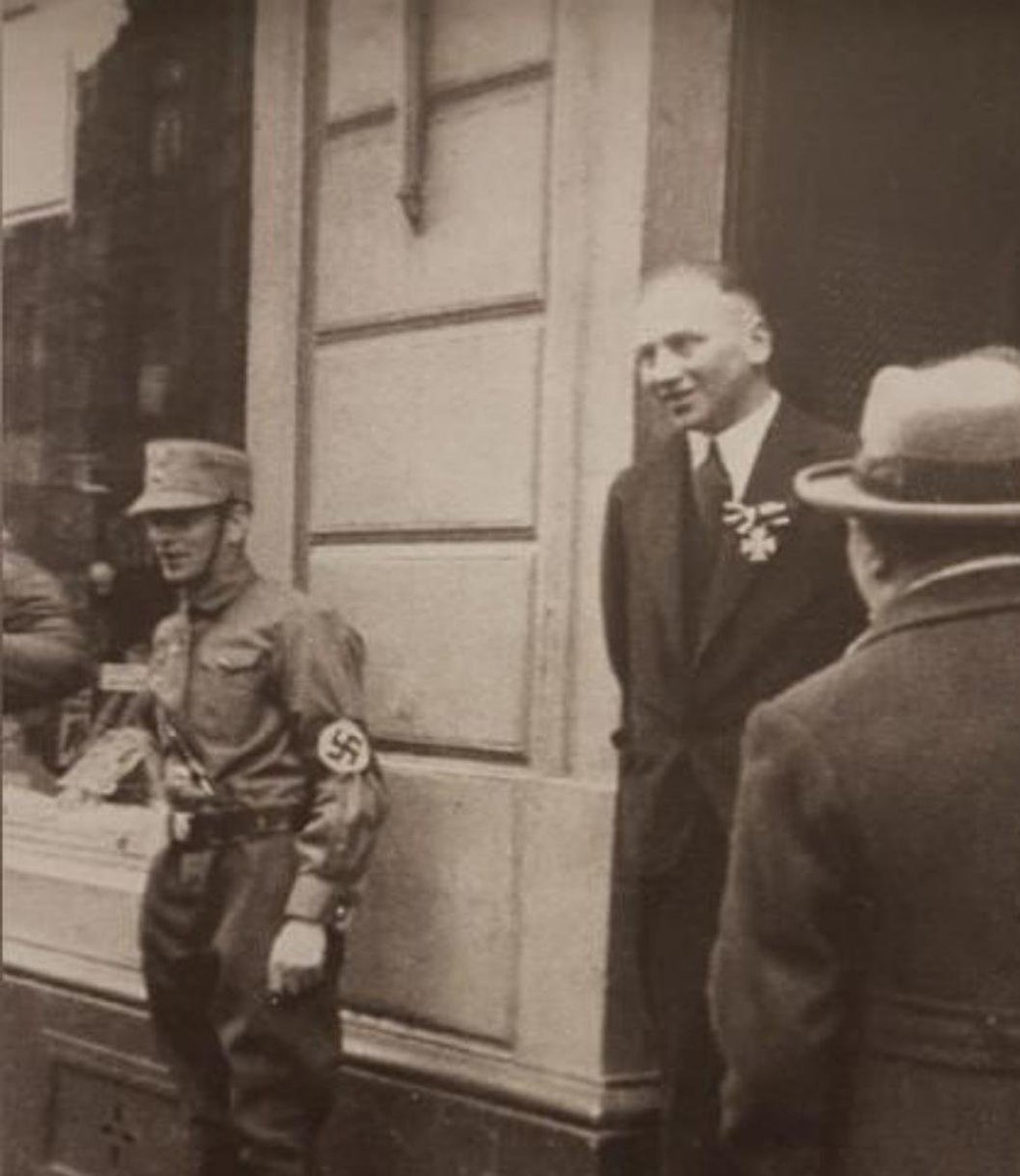 NateLavi's tweet photo. @NiohBerg A German Jewish veteran of WW1 wears his Iron Cross while a Nazi soldier stands in front of his shop for intimidation (1933) https://t.co/5Bal8okzDj
