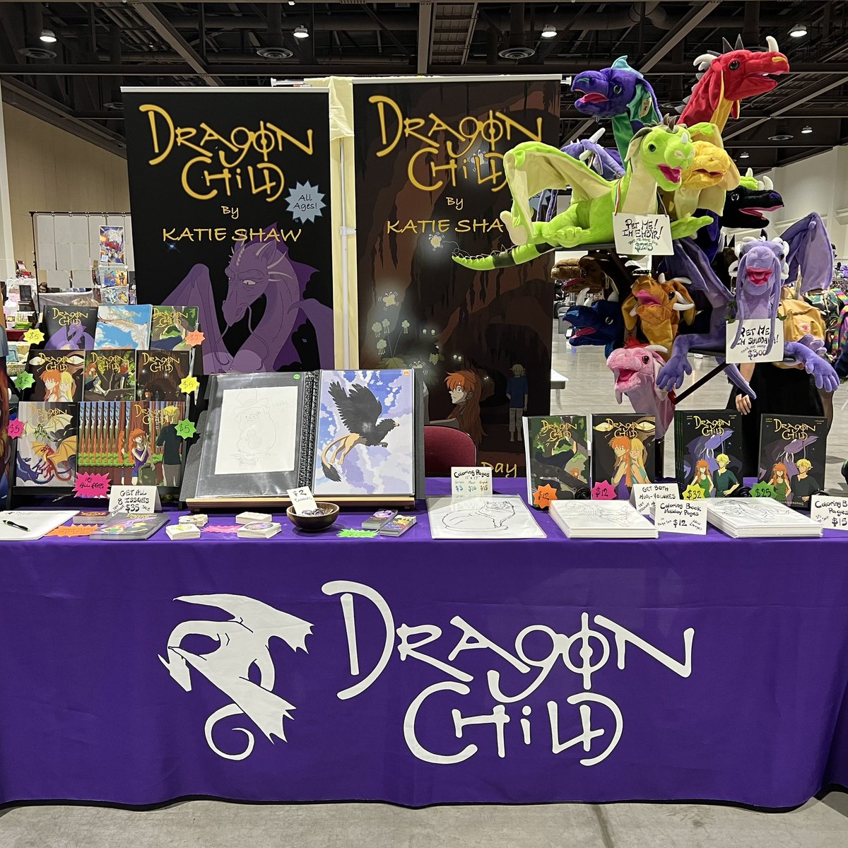 DragonChildKS's tweet photo. We’re at Silver Age Comic Con in the Reno-Sparks Convention Center.  If you’re in the Reno, NV area this weekend, come check out this fun event!  You can find us in Hall 5.  Look for the purple tablecloth and the tree full of dragons!

#silveragecomiccon #dragons #comics https://t.co/ptqR8P7Djy