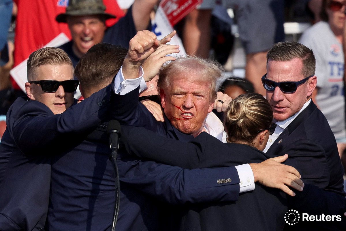 Republican presidential candidate and former U.S. President Donald Trump is assisted by U.S. Secret Service after gunfire rang out during a campaign rally at the Butler Farm Show in Butler, Pennsylvania. Photo by Brendan McDermid