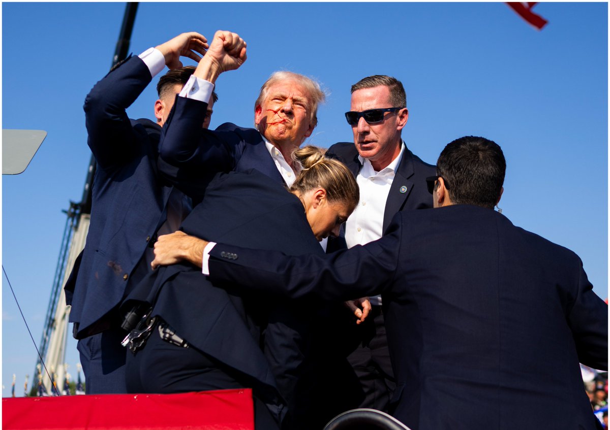 Surrounded by members of the Secret Service, <a href="/realDonaldTrump/">Donald J. Trump</a> pumps his fist with blood on his face, during a rally in Butler, PA.