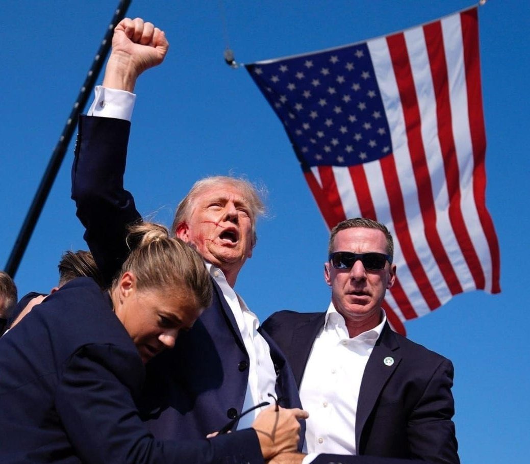 marilongui's tweet image. Le acaban de pegar dos tiros y el chad levanta el puño con la bandera de Estados Unidos de fondo.

Ganador, fin.