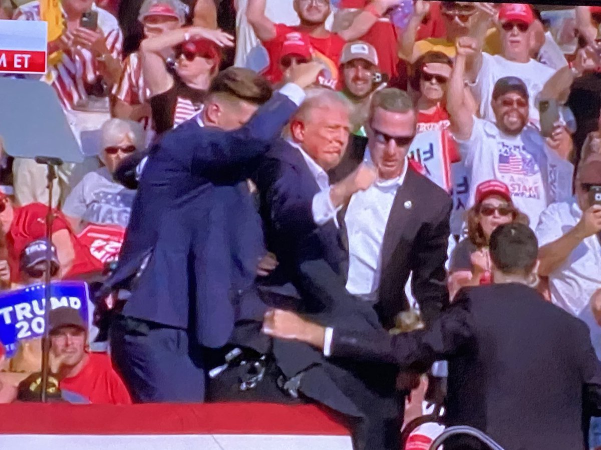 choquei's tweet photo. 🚨URGENTE: Donald Trump é visto sangrando após tiroteio em seu comício, na Pensilvânia, nos Estados Unidos. https://t.co/Enz7KNqjmv