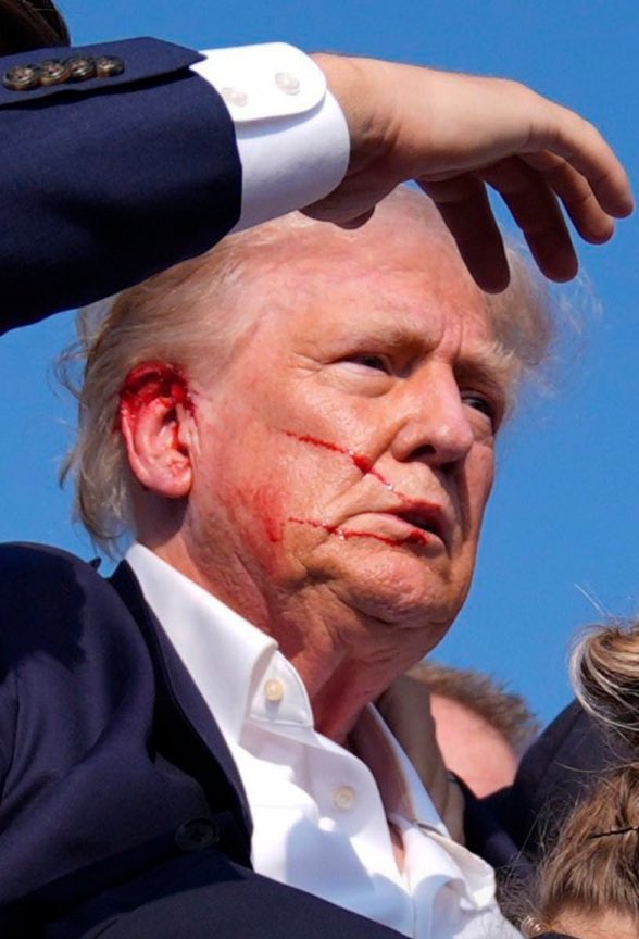 CalltoActivism's tweet photo. First image of Donald Trump after being shot in Pennsylvania. 

We stand against political violence in all forms. This is what we are fighting against. 

Trump’s rhetoric is dangerous. https://t.co/HyYpkAGAv7