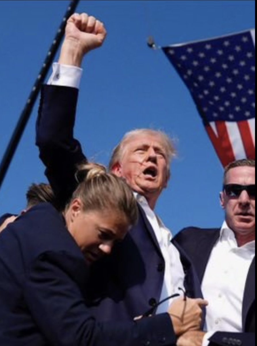 thesapyo's tweet photo. Trump Pensilvanya Mitinginde suikaste uğradı. Kulağından vurulan Trump'ın durumu iyi. Kanlar içinde korumaları tarafından ayağa kalkarken yumruğunu da havaya kaldırarak güçlü bir meydan okuma yaptı. https://t.co/qrDx0arLJ5
