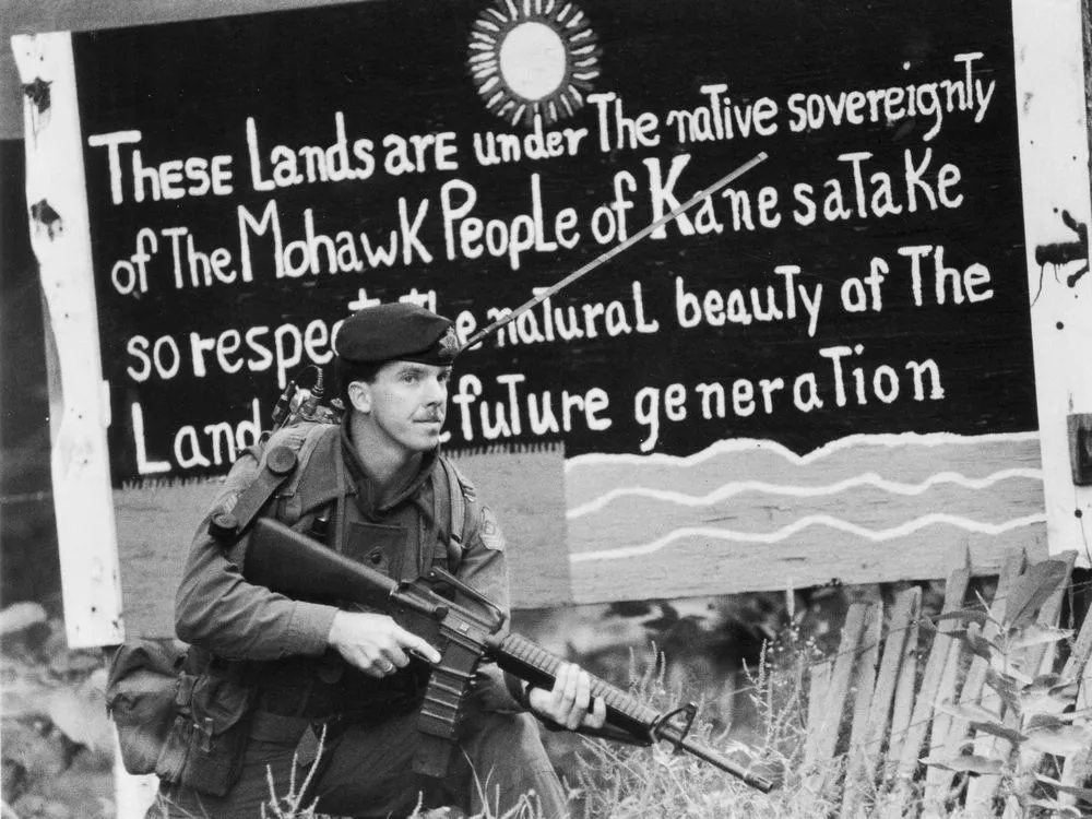 MrDeLaronde's tweet photo. OKA Crisis. The crisis was sparked by the proposed expansion of a golf course and the development of townhouses on disputed land in the Pines that included a Kanyen'kehà:ka burial ground. https://t.co/uBeU5ikuyd