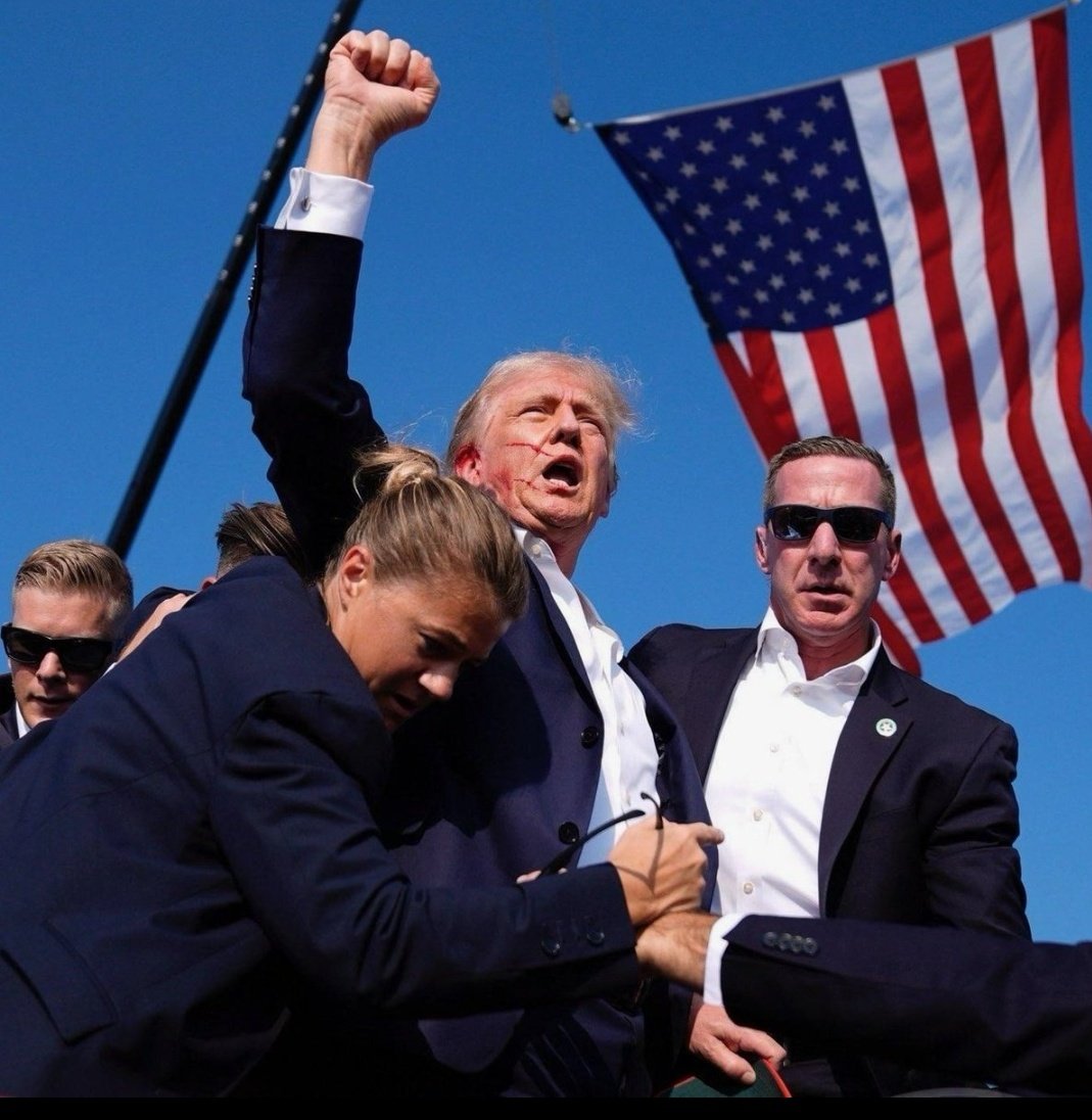 SirishM's tweet photo. That was Trump’s Mudhalvan moment.. they couldn’t have got a better pic than him with blood, hand raised and flag in the background.. and jus like Arjun, he’s gonna sweep the election. #DonaldTrump #AssassinationAttempt #Shankar https://t.co/gYGhPkyGQD