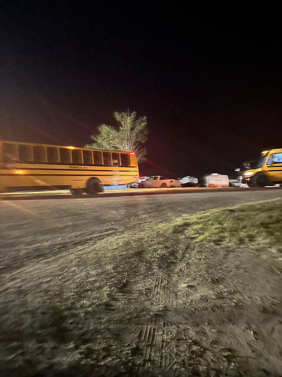 dinherr's tweet photo. @countrythunder hundreds of people in line for the shuttle service for hours, why were there buses sitting idle by the entrance? these 2 buses on the dirt road leading in, and 3 buses idle on the highway. absolutely brutal. #countrythundersk https://t.co/KQeOZlluUX