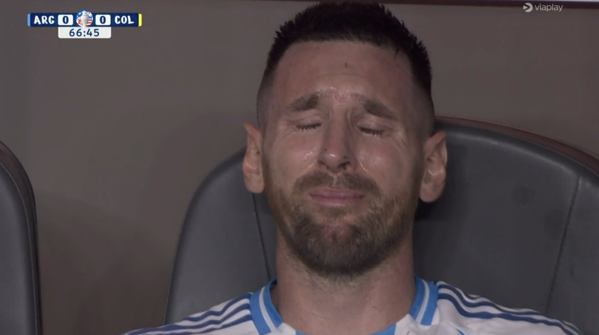 NosyBuzzer's tweet photo. Lionel Messi drops to the pitch in pain during the CONMEBOL 2024 Copa America tournament final football match. 🥺

He is out in tears as his night is apparently OVER!!! 😢😭

 An emotional moment.. END of the GOATs' ERA [Ronaldo & Messi]

#LEO #CR7 #Lionel #MagicalMessi #MessiFC #leomessi #GOAT #soccer #football #KarolG  #Shakira #CONMEBOLCopaAmérica #Conmebol #CopaAmerica2024 #argentinavscolombia #colombiavsargentina #colombia #HalfTimeShow #nationalAnthem #Popstar #AbelPintos #argentina #Messi𓃵 #LionelMessi #football #futbol #latinpop #CopaAmerica #CopaAmérica #miami #florida #hardrockstadium #CA2024 #latina #latinx #latino