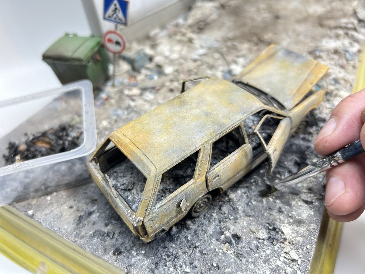 takepon407's tweet photo. 以前製作していた全焼した乗用車をジオラマの地面に固定して馴染ませる為にウェザリングカラーの黒で車両周辺の色変化をだす。新聞紙やダンボールを燃やした灰と微細な石膏の粉末と灰色のピグメントを使い、高温で焼けた燃えかすを再現。車両の底部には配線類の燃え残りなども配置する。 https://t.co/ppJQvy1EnK