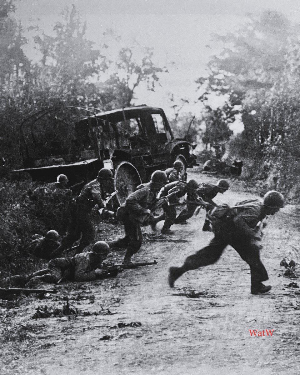 TheWorldatWar2's tweet photo. US infantry run for cover across a road and past a wrecked German transport near St-Lo - July 1944 #stlo #normandy #normandie #july1944 https://t.co/RaWsKtbgQq