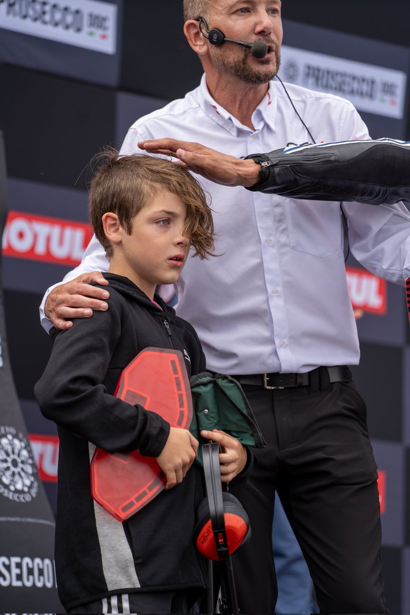 Dazmoto748's tweet photo. This little lad lost his dad at Donington. @mhillofficial took him onto the stage while @toprak_tr54 was on the podium and handed him the fastest lap trophy. 10 seconds later his relieved dad turned up. 🙏If anyone knows the dad I'll pass these photos on https://t.co/w2cx034XSI